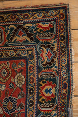 Antique Qashqai rug corner showcasing intricate jewel-tone patterns and worn fringed edge.