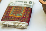 Pazyryk CoasterRug set with ivory fringe and vivid red, green, gold geometric pattern.