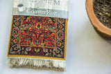 CoasterRug displaying intricate red, gold, black, and teal tendril and vine pattern with fringe.