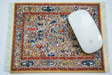 Intricate Persian Oriental mouse pad with red, blue, gold Soumac design and white mouse.