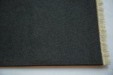 Dark gray textured backing and light ivory fringe of the MouseRug mouse pad.