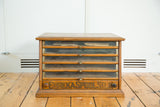 Aged oak and original glass-front upper drawers of the Victorian spool cabinet.