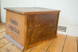 Side of antique Eureka Spool Silk cabinet, highlighting original branding and rich wood patina.