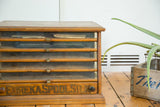 Bottom drawer of antique Victorian Eureka Spool Silk cabinet with glass panel and wood knob.