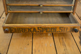 Open drawer of antique Eureka Spool Silk cabinet, displaying 'EUREKA SPOOL SILK' lettering.