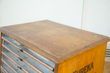 Aged oak top with visible patina and partial 'Eureka' lettering on a Victorian cabinet.