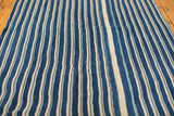 Textured hand woven indigo blue and off-white striped textile with varied tones.