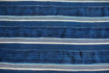 Detail of vintage indigo throw, showing textured hand-woven blue and cream stripes.
