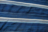 Collectible handwoven African indigo throw with varying blue stripes and visible seams.
