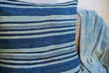 Textured vintage African indigo pillow with varying medium and dark blue stripes.