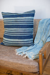 Dark indigo striped pillow alongside a light blue handwoven textile.