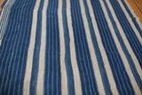 Hand-woven cotton textile featuring varied indigo blue and cream stripes.