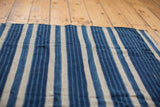 Varied indigo blue stripes and hand-woven texture on a vintage cotton textile.
