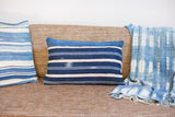 Dark indigo striped lumbar pillow, revealing varied handwoven texture and an adjacent light textile.