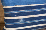 Detail of handwoven indigo striped lumbar pillow, highlighting unique dye differences and texture.