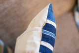 Side detail of handwoven indigo pillow with diverse blue and cream striped texture.