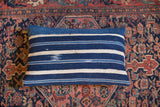 Handwoven striped indigo lumbar pillow featuring subtle blue dye variations.