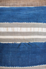 Textured handwoven indigo mudcloth pillow with thick blue, grey, and white stripes.