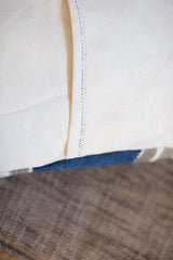 Indigo Mudcloth Pillow's cream canvas back, double-color envelope stitching, and indigo textile edge.