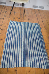 Hand-woven vintage African indigo textile featuring varied blue and cream vertical stripes.