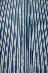 Hand-woven indigo blue striped textile, showcasing varying tones and subtle cotton texture.