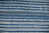 Hand-woven cotton textile, showcasing variegated indigo blue and natural white stripes.