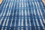 Handwoven indigo collectible textile featuring geometric patterns in deep blue and cream.