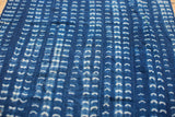 Collectible hand-woven indigo textile with intricate white resist-dyed patterns and texture.