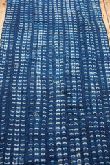Hand-woven African indigo textile, showcasing unique hand-dyed white patterns and aged character.