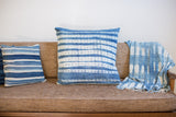 Large 24x24 inch vintage African indigo textile pillow with faded blue and white batik stripes.