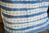 Handwoven African indigo pillow detail, showing faded blue Batik stripes and textured patina.