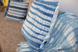 Faded indigo blue pillow with organic white batik stripes and handwoven textile texture.