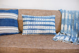 Textured handwoven Batik indigo lumbar pillow with faded stripes.
