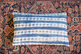 Batik Indigo Lumbar Pillow featuring a faded blue and white handwoven striped pattern.