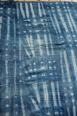 Handwoven African indigo textile with white batik stripe patterns and unique character.