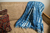 Supple indigo blue cotton throw with fringed edge and white batik pattern.