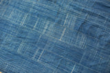 Collectible vintage indigo textile detail with faded blue linear patterns and handwoven cotton texture.