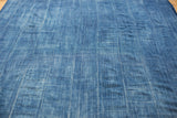 Close-up of the vintage hand-woven indigo textile, showing denim texture and varied blue shades.
