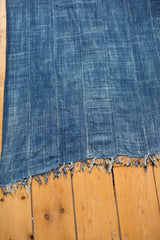 Hand-woven vintage indigo throw featuring varied denim blue tones, striped pattern, and rustic fringe.