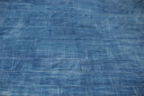 Vintage African indigo textile, close-up of hand-woven texture and blue color variations.