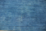 Denim indigo hand-woven textile, highlighting horizontal strips and a visible vintage repair.