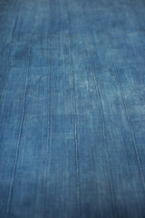 Angled close-up of the vintage African indigo textile with handwoven vertical stitched lines.