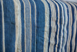 Hand-woven indigo throw, textured cotton with diverse blue stripes and panel seams.