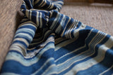 Textured hand woven vintage indigo stripe textile with varying blue and natural tones.