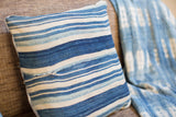 Finely woven indigo pillow with varied blue and ivory stripes.