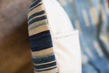 Side view of striped indigo pillow, showing ivory canvas backing and double stitch.