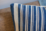 Finely woven indigo and off-white striped textile of a vintage African pillow.