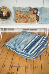 Textured vintage indigo floor pillow, showcasing unique blue and white irregular stripes.