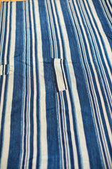 Collector's hand-woven indigo textile, featuring varied blue stripes and stitched fabric segments.