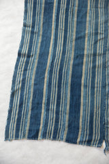 Vintage African indigo textile featuring hand woven blue and natural stripes with frayed seams.